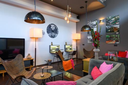 a living room with a couch and chairs at SleepinRoomz Boutique Hotel in Dortmund