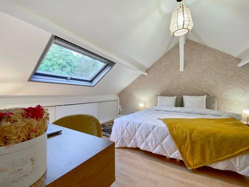 une chambre mansardée avec un lit et une fenêtre dans l'établissement La Douceur de la Seine - 305, à Amfreville-la-Mi-Voie