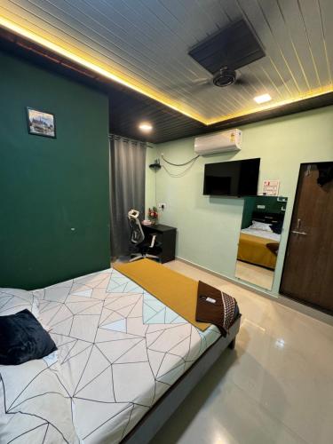 a bedroom with a large bed with a green wall at soge holiday lodging in Srīvardhan