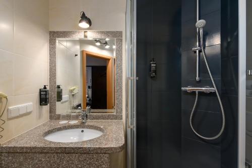 a bathroom with a sink and a shower at SleepinRoomz Boutique Hotel in Dortmund