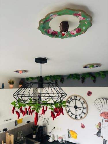 a chandelier in a kitchen with a clock on the wall at THE ENCHANTED HOUSE ( 15 min walk to Disney) in Serris