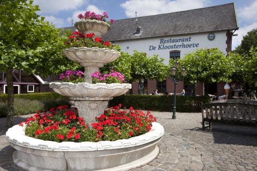 a large concrete fountain with flowers in a courtyard at Vakantiepark Klein Vink - 25 in Arcen