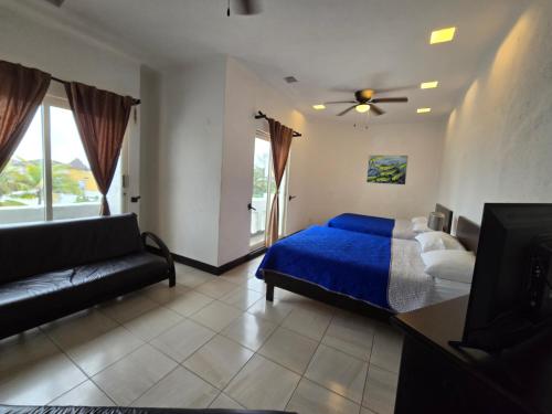 a bedroom with a blue bed and a couch at Hotel Villa Capricho in Ciudad Madero