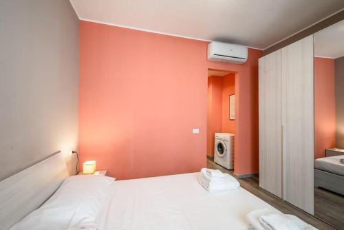 Un dormitorio con dos camas y una pared naranja. en Casa Pasteur 3 minutes from metro WIFI AC, en Milán