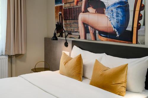 a bedroom with a bed with pillows and a picture on the wall at SleepinRoomz Boutique Hotel in Dortmund
