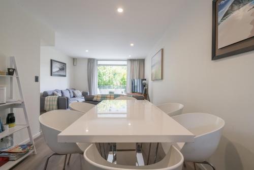 a living room with a white table and chairs at Spacious Home Near CBD SPA Pool Parking 3BR in Auckland