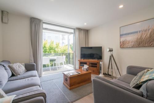 a living room with two couches and a flat screen tv at Spacious Home Near CBD SPA Pool Parking 3BR in Auckland