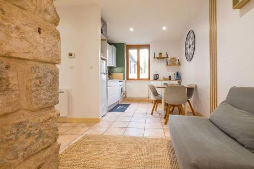 un salon avec un canapé et une cuisine avec une table dans l'établissement Le jardin des Plantes, à Dijon