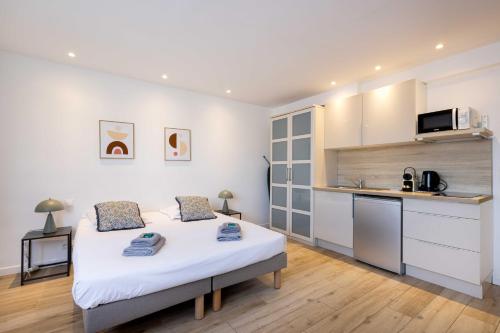 une chambre avec un grand lit et une cuisine dans l'établissement Agence des Résidences - Appartements privés du 45 CROISETTE - Standard, à Cannes