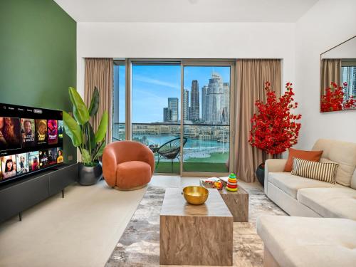 a living room with a view of a city at Luxury Two Bedroom Apartment with Balcony, Full Burj Khalifa & Fountain Views by Delujo Stays in Dubai