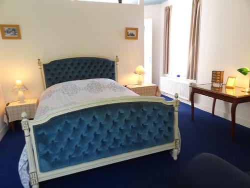 - un lit bleu dans une chambre avec fenêtre dans l'établissement Le Manoir des Parcs, Piscine chauffée, à Ouilly-le-Vicomte