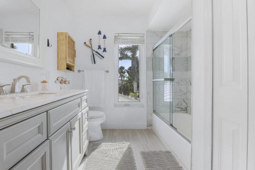 un bagno bianco con doccia e WC di Waterfront Living, Dock, Heated Pool & Spa - Gulf Gate Oasis - Roelens a Cape Coral