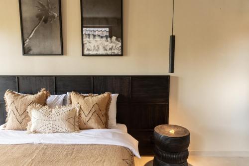 a bedroom with a bed with a wooden headboard at TheSoulHouseBali in Canggu