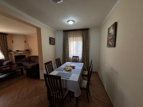 a dining room with a table and chairs and a living room at Villa del Mare in Dobra Voda