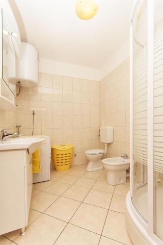 a bathroom with a sink and a toilet and a shower at Apartments Brane in Postira