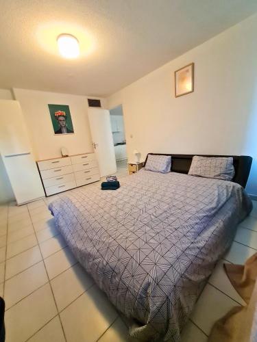 une chambre avec un lit avec une couette violette dans l'établissement Escale en ville - T2 lumineux gare centre-ville, à Montpellier