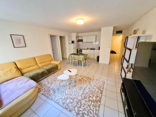 un salon avec un canapé et une table dans l'établissement Escale en ville - T2 lumineux gare centre-ville, à Montpellier
