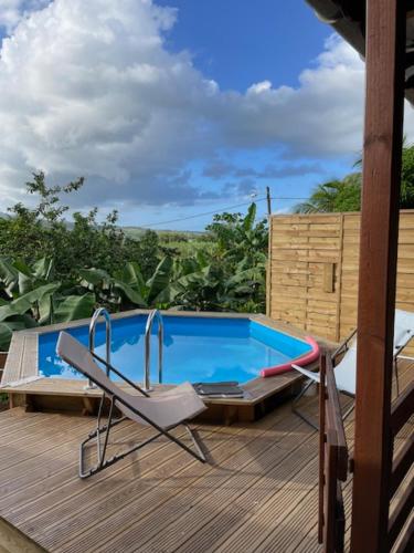 a deck with a chair and a swimming pool at Villa MORINGA in Lamentin
