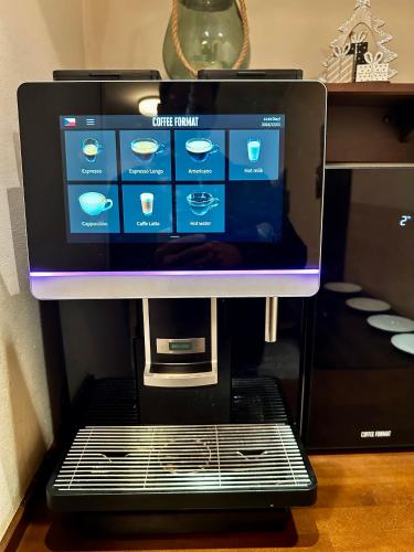 een computerscherm bovenop een koffiezetapparaat bij Anyday Apartments in Praag