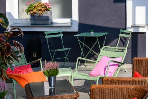 a patio with chairs and a table with flowers at SleepinRoomz Boutique Hotel in Dortmund