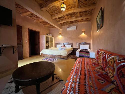 een woonkamer met 2 bedden en een bank bij Palais D'Ouzoud in Azilal