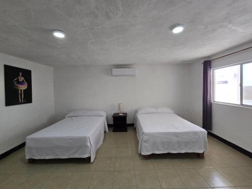 a room with two beds and a window at Hotel Villa Capricho in Ciudad Madero
