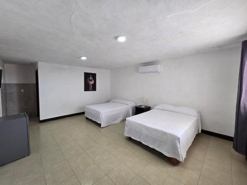 a room with two beds and a tv in it at Hotel Villa Capricho in Ciudad Madero