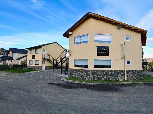 a building on a street next to a house at Laderas Blancas in Caviahue