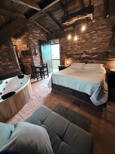 a bedroom with a large bed and a bath tub at El Agrado Restaurante Cabañas in Líbano