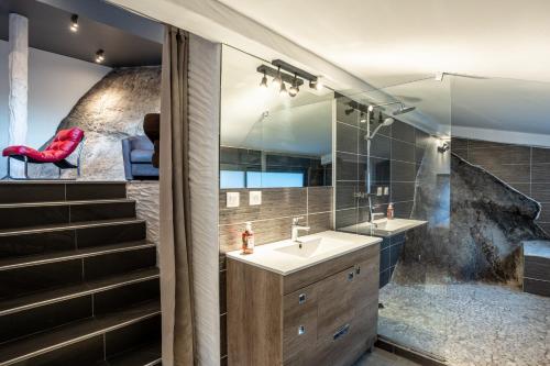 La salle de bains est pourvue d'un lavabo et d'une chaise rouge. dans l'établissement La Verrière du Lac, à Sévrier