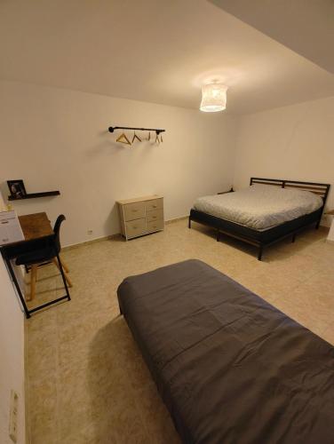 une chambre avec deux lits, un bureau et une chaise dans l'établissement Cosy Ciné 8, à Pont-de-lʼArche