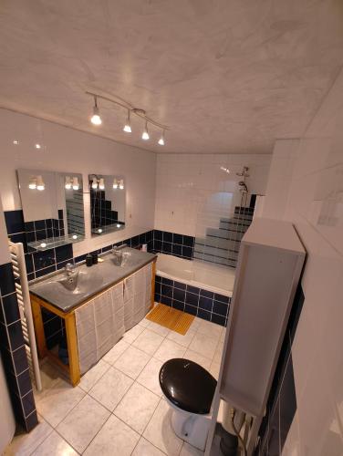 une salle de bain avec deux lavabos et une baignoire dans l'établissement Cosy Ciné 8, à Pont-de-lʼArche