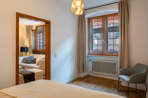 a bedroom with a bed and a chair and a window at Ferienwohnung Gasthaus zum Kranz in Freiburg im Breisgau