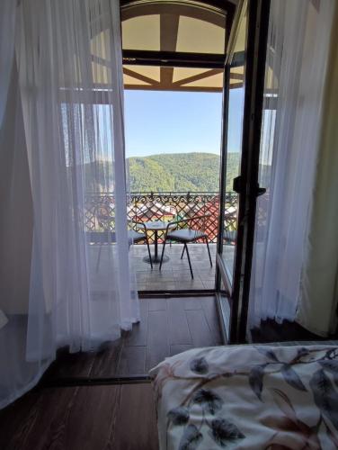a room with a bed and a balcony with a view at Карпатська Вершина in Yaremche