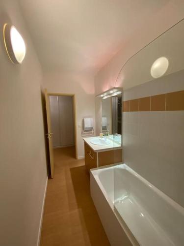 une salle de bain avec une baignoire, un lavabo et un miroir dans l'établissement Bel Appartement Chaleureux 306 - Le Garbet - Résidence Grand Hôtel, à Aulus-les-Bains
