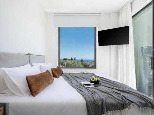 a bedroom with a white bed with a large window at Sunny Vacay Villa in Stérnai