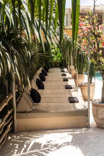 a row of shoes on a wooden walkway with plants at TheSoulHouseBali in Canggu