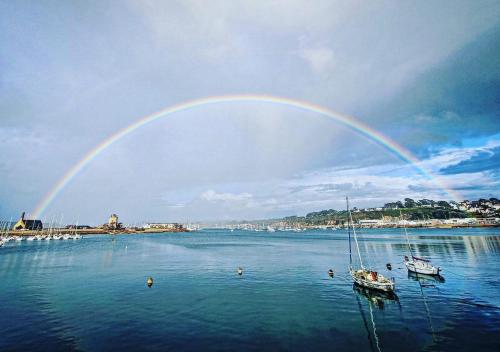 a rainbow over a body of water with boats at La Langouste ROUGE in Camaret-sur-Mer