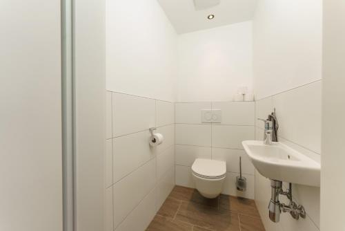ein weißes Badezimmer mit Toilette und Waschbecken in der Unterkunft Neues Luxus APARTMENT DACHSTEIN - Ramsau am Dachstein - inklusive SOMMERCARD ! in Ramsau am Dachstein