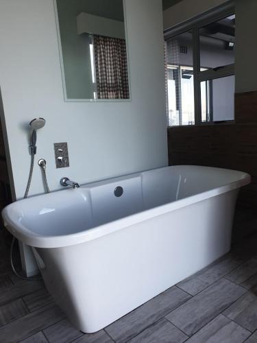 a white bath tub in a bathroom with a mirror at Malibu Waters in Port Edward