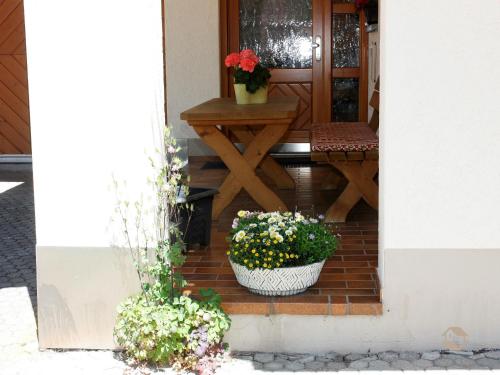 a porch with two potted plants and a table at Haus Ingrid in Schluchsee