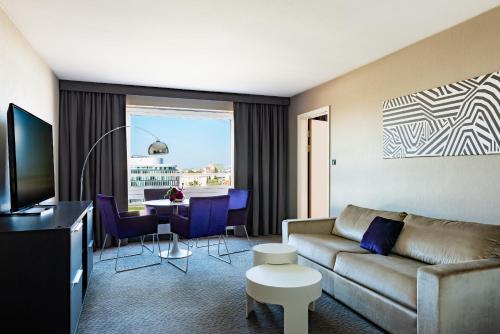 a living room with a couch and a table at Sofitel Warsaw Victoria in Warsaw