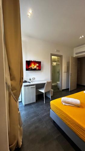 a hotel room with two beds and a desk with a fireplace at B&B Margherita in Messina