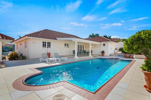 a swimming pool in front of a house at Rooi Koochi 27D in Savaneta