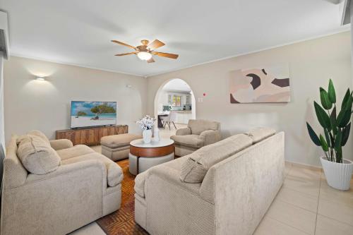 a living room with couches and a ceiling fan at Rooi Koochi 27D in Savaneta