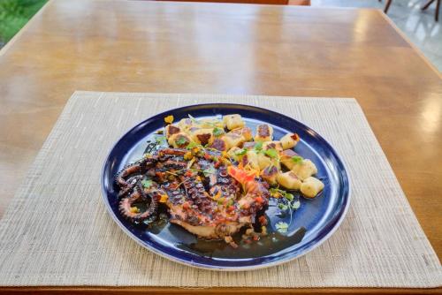 a blue plate of food on a wooden table at Mercure Rio de Janeiro Barra da Tijuca in Rio de Janeiro