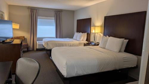 una camera d'albergo con due letti e una televisione di Sonesta Essential Columbus a Columbus