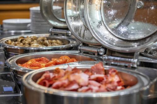 a bunch of food in metal pans on a counter at Meon Valley Hotel, Golf & Country Club in Shedfield