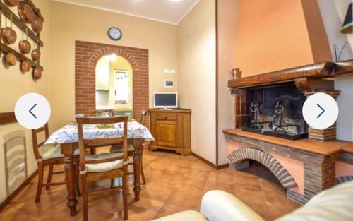 a living room with a table and a fireplace at Casa Martina in Camaiore