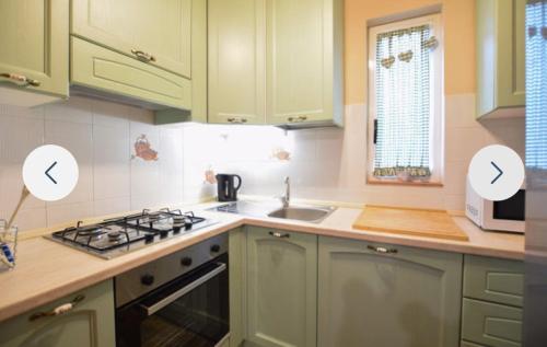 a kitchen with green cabinets and a sink at Casa Martina in Camaiore